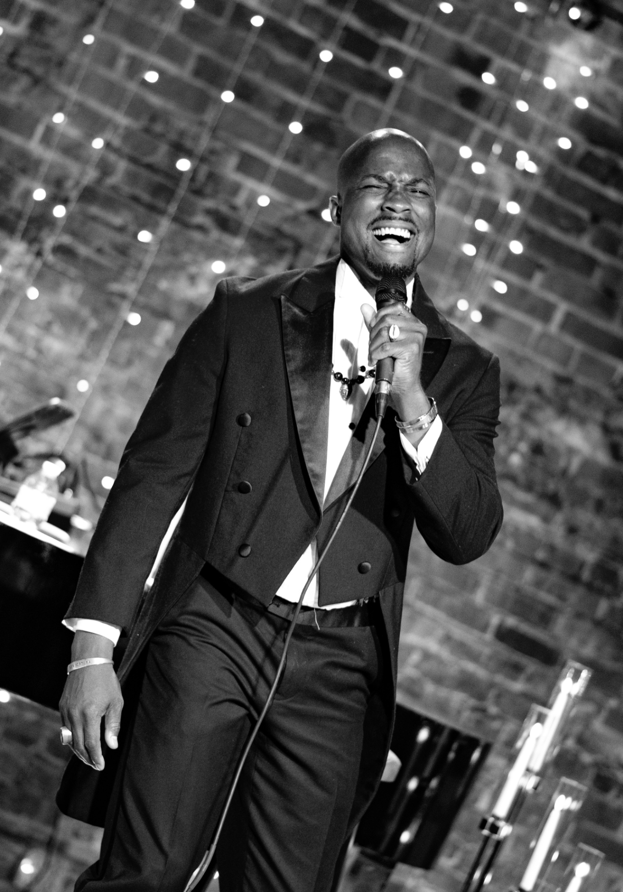 Black and white portrait of Elias Hendricks mid-song, smiling