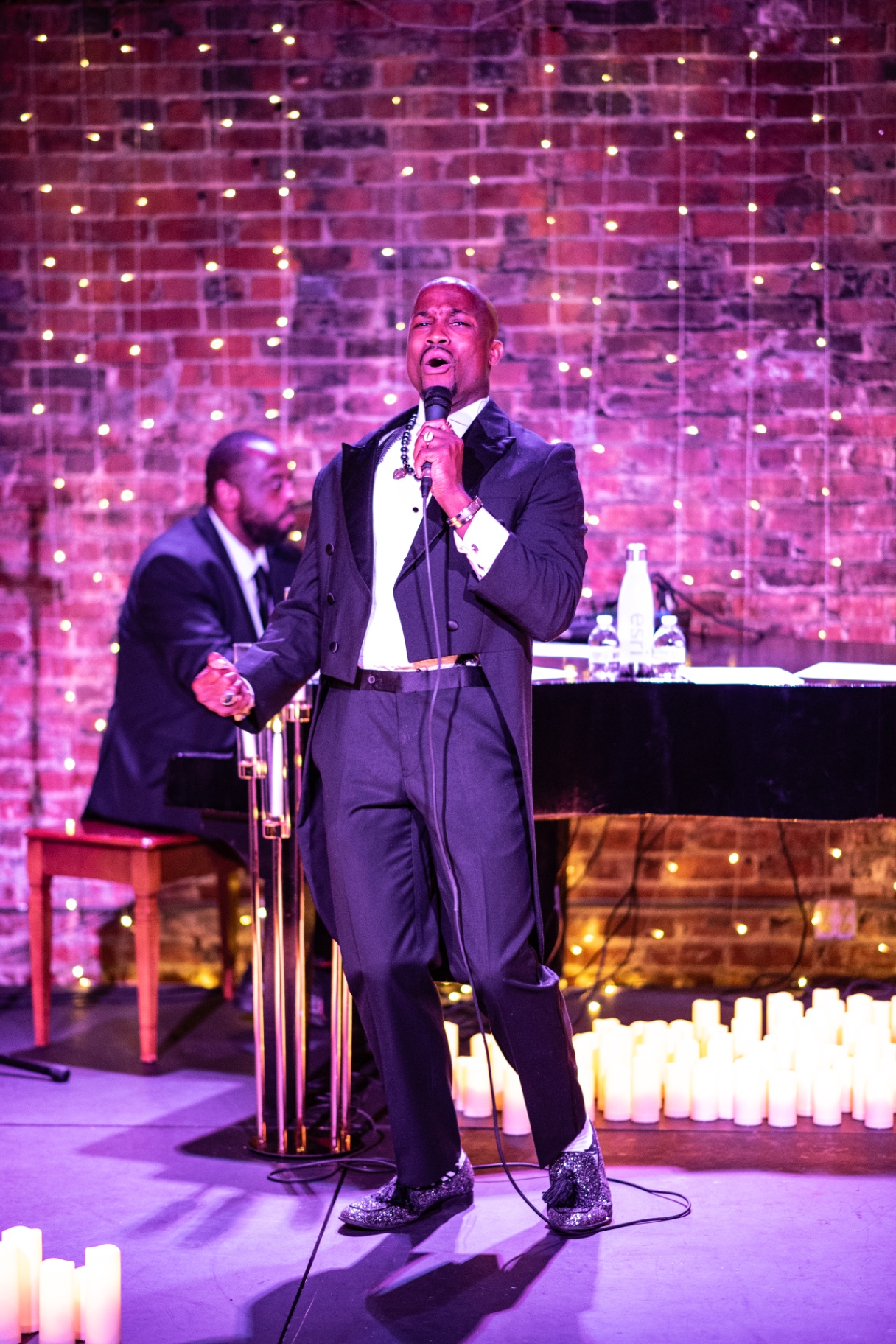 Elias Hendricks reaching out to the audience during a candlelit performance