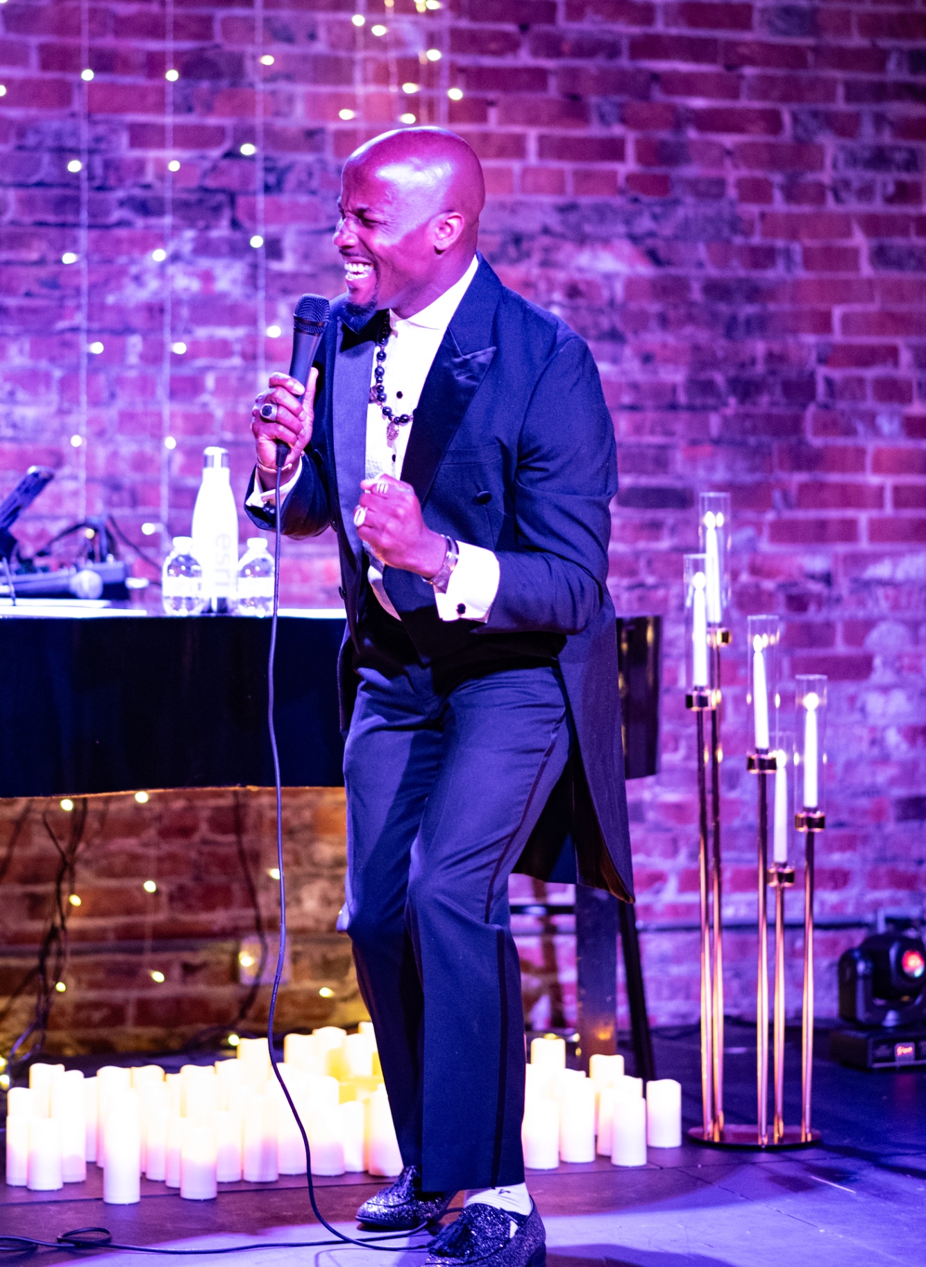 Elias Hendricks laughing mid-song at a candlelit Classical Soul concert