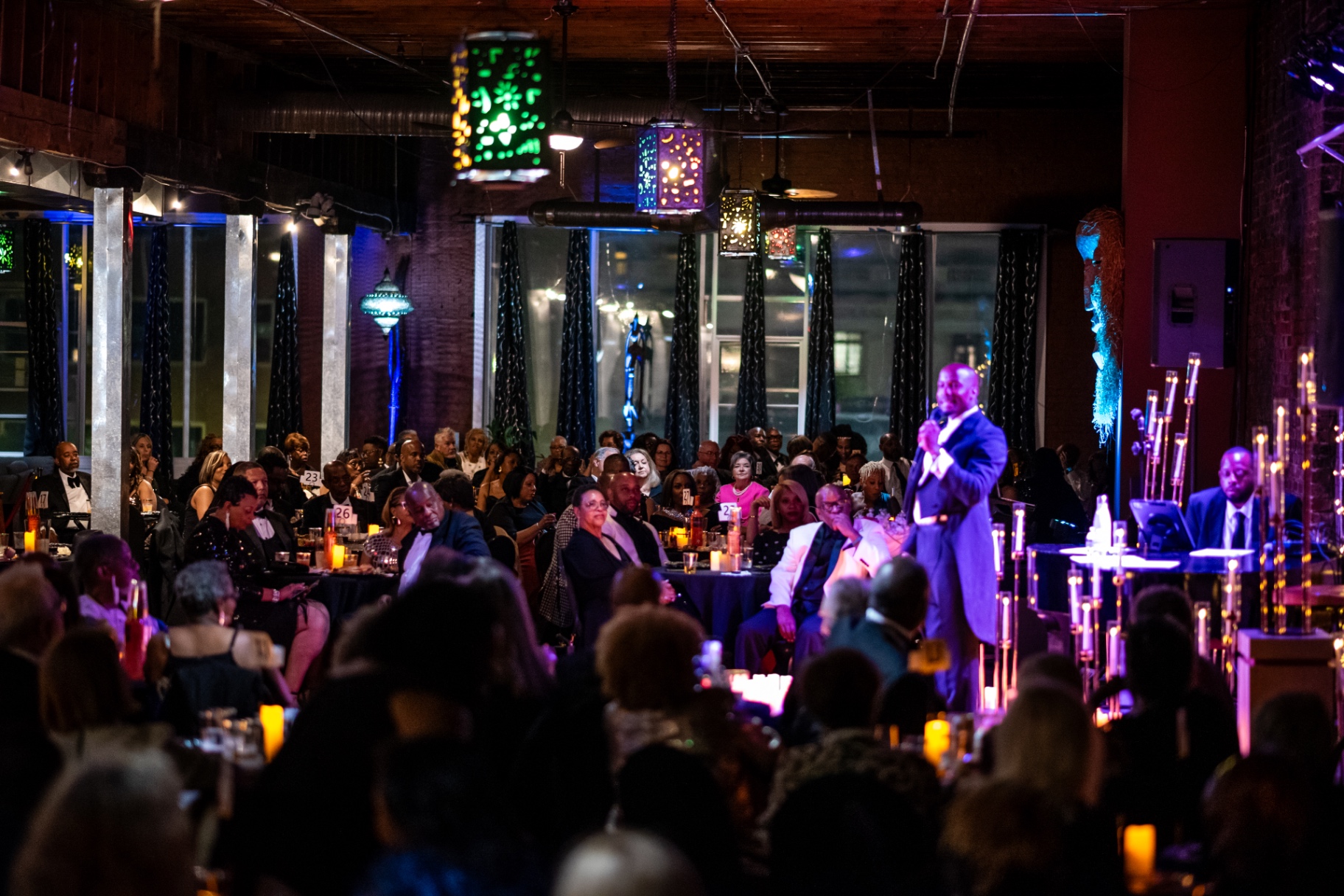 A full candlelit dining room watching Elias Hendricks perform at the piano