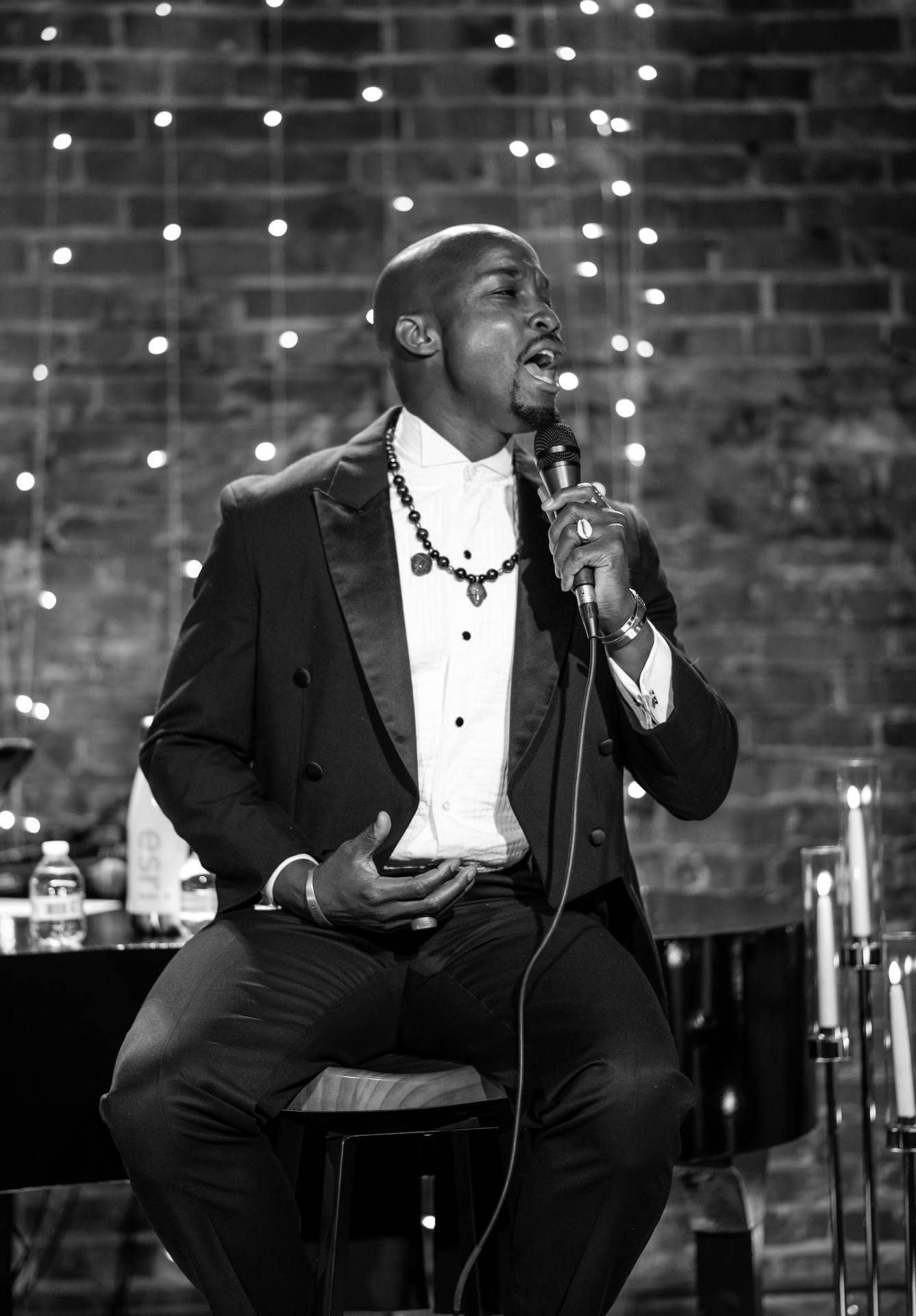 Black and white portrait of Elias Hendricks singing seated on stage