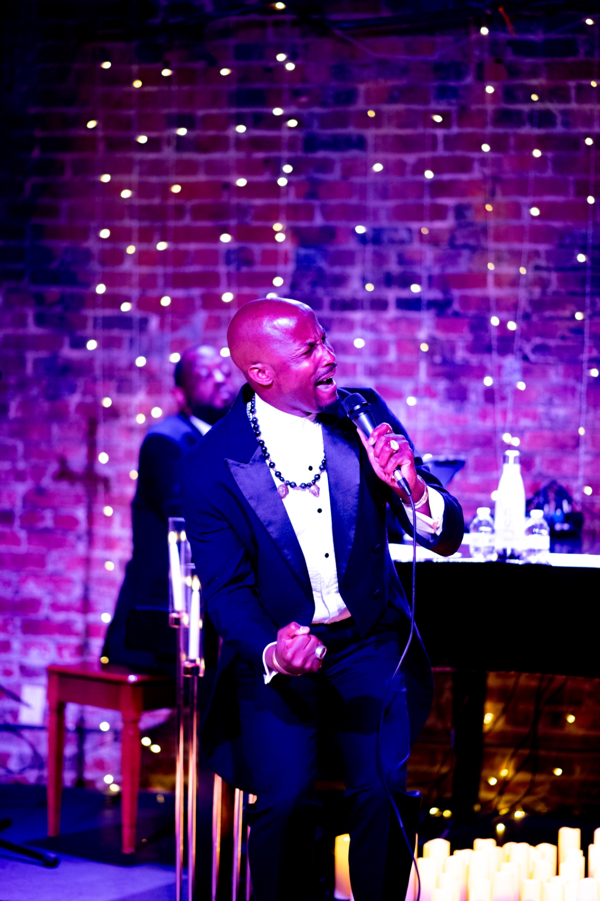 Elias Hendricks singing with his pianist at a candlelit concert