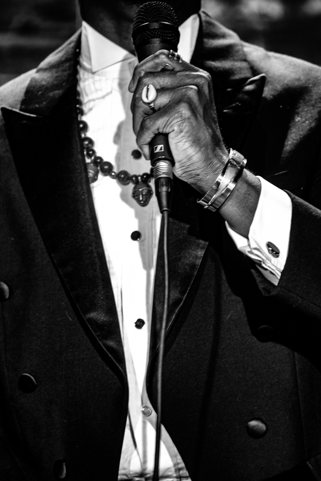 Black and white close-up of Elias Hendricks's hand on the microphone